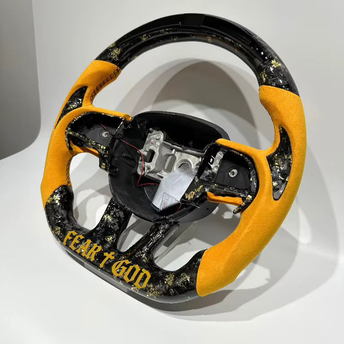 Volante personalizado amarillo con fibra forjada y detalles dorados